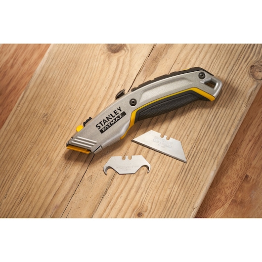 Photo of STANLEY 0-10-789 utility knife and two spare blades on wooden surface.