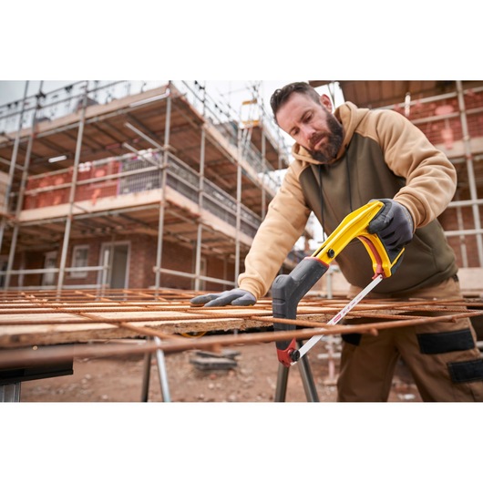 STANLEY 0-20-108 hacksaw cutting metal rods on construction site, side angle, worker wearing gloves.