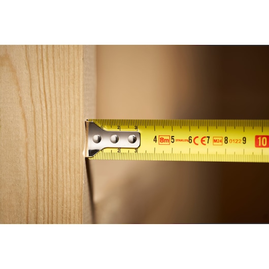 STANLEY 0-30-657 tape measure close-up with yellow blade extended, measuring wood surface.