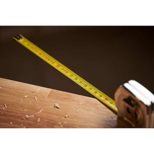 STANLEY 0-33-218 tape measure photography of yellow blade extended on wooden surface.