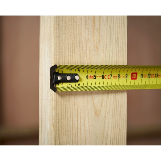 STANLEY 0-33-720 tape measure measuring wooden plank, close-up photography.