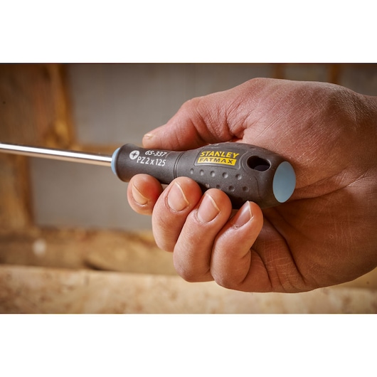 Stanley 0-65-337 screwdriver with black and yellow handle, held in hand, close-up view.