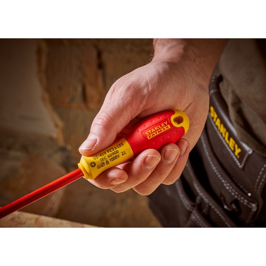 STANLEY 0-65-419 insulated screwdriver with red and yellow handle held in hand, close-up view.