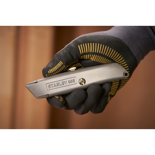 STANLEY 1-10-099 utility knife held in gloved hand, product close-up photography.