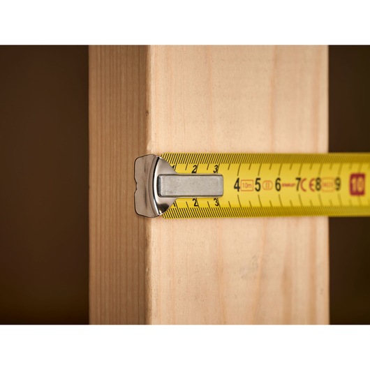 STANLEY 1-33-442 tape measure measuring wooden plank, close-up side view.
