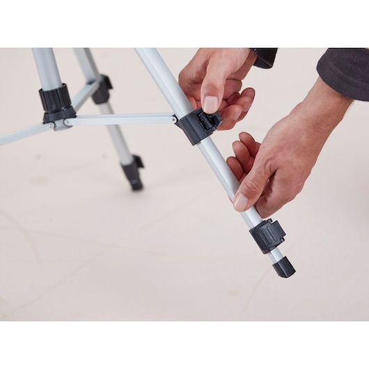 STANLEY 1-77-201 tripod photography, hands adjusting leg clamp on silver and black tripod.