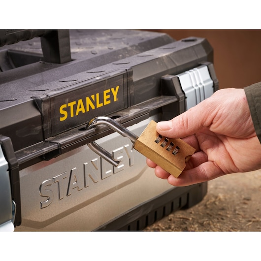 STANLEY 1-95-619 toolbox front view with a hand unlocking a brass combination padlock.