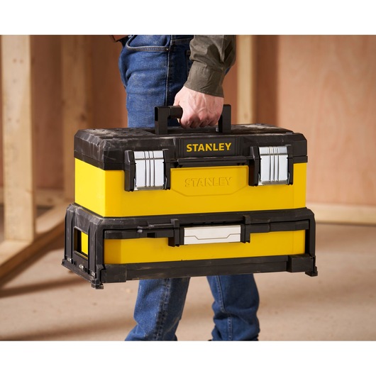 STANLEY 1-95-829 toolbox, yellow and black with metal latches, carried by hand, product use context.