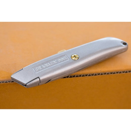 STANLEY 2-10-099 silver utility knife on cardboard, product side view.