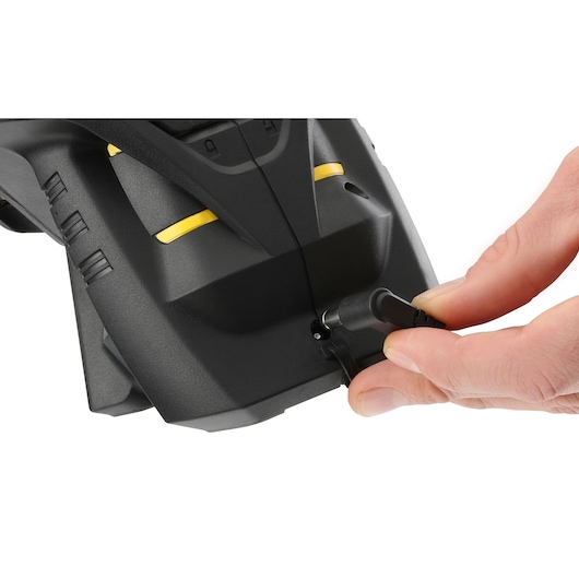 Photo of STANLEY FMHT1-77356 charging port close-up, hand plugging in power cable, photography product.