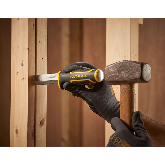 Stanley FMHT16693-0 chisel with FATMAX handle in use on wooden frame, struck by hammer.