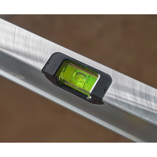Stanley FMHT43677 level close-up showing green vial and silver aluminum body, angled view.