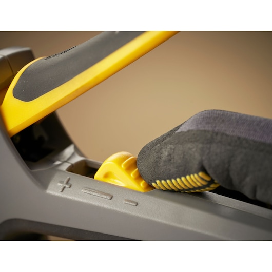 STANLEY FMHT6-70868 photography, close-up of gloved hand adjusting yellow feature on tool handle.