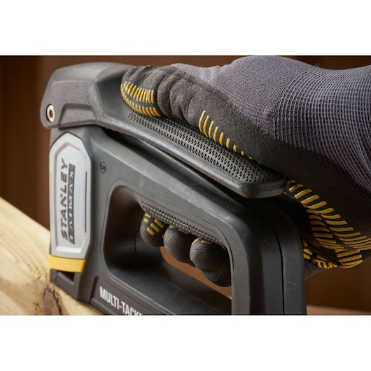 STANLEY FMHT70401-0 stapler held by gloved hand on wood, close-up angle