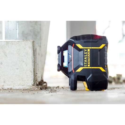 STANLEY FMHT77446-1 laser level in black and yellow on construction floor, side angle.