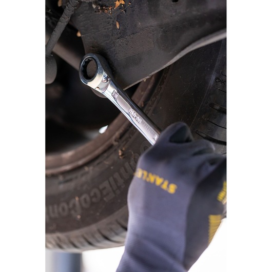 Photo of STANLEY FMMT82849-0 ratcheting wrench in use on a car, hand wearing STANLEY glove.