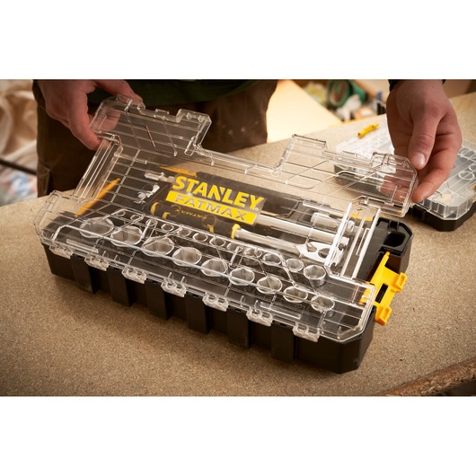 STANLEY FMMT98103-1 organizer box with clear lid and FATMAX branding, held by hands, on a workbench.