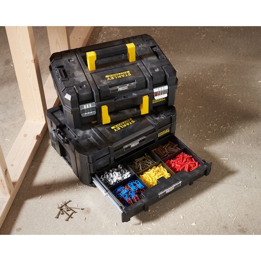 STANLEY FMST1-71981 black stackable toolboxes with yellow handles, one open drawer showing organized hardware compartments.