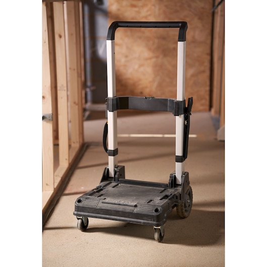 STANLEY FMST1-72363 folding hand truck with black and silver frame on construction site floor.