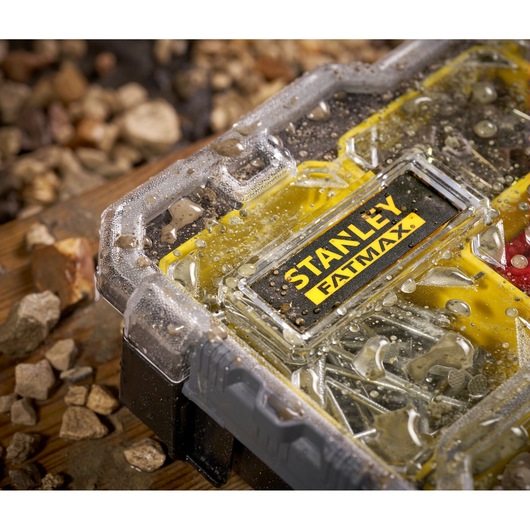 Photo of STANLEY FMST1-75781 waterproof small parts organizer with water droplets on clear lid, surrounded by rocks.