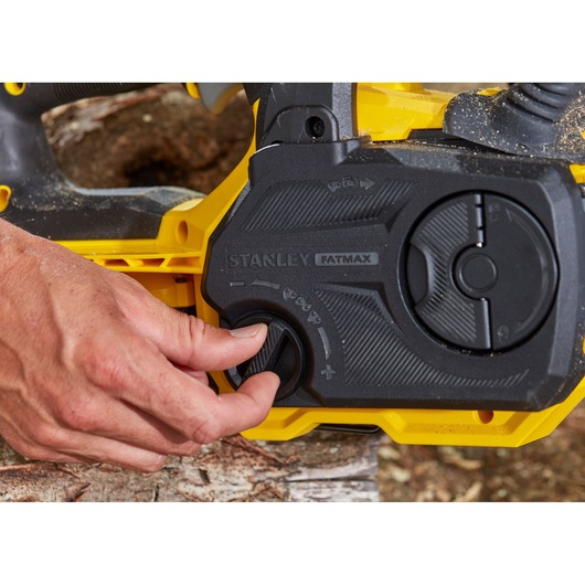 Photo of STANLEY SFMCCS630M1 chainsaw control panel with hand adjusting knob, close-up angle.