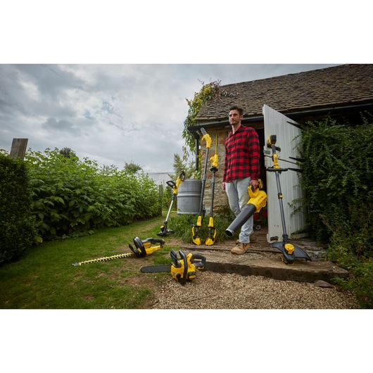 STANLEY SFMCCS630M1 garden power tool set, including hedge trimmer, chainsaw, leaf blower, and strimmer, outdoor scene.