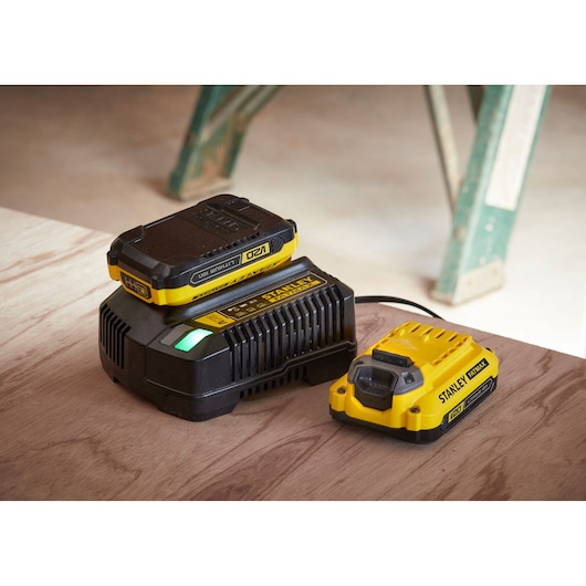 STANLEY SFMCD710C2K battery charger and battery set on wood surface, product front angle.