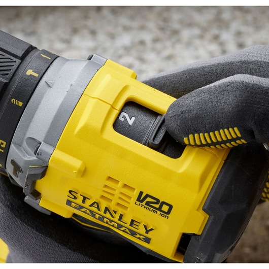 Close-up of STANLEY SFMCD715M2K power drill speed selector, yellow and black, with glove adjusting switch.