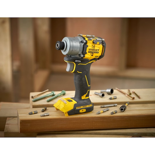 STANLEY SFMCF830B cordless impact driver on wooden beams with drill bits and screws.