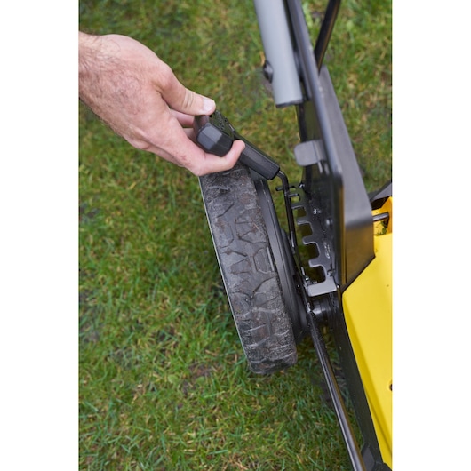 STANLEY SFMCMWS251B mower close-up showing wheel height adjustment mechanism.