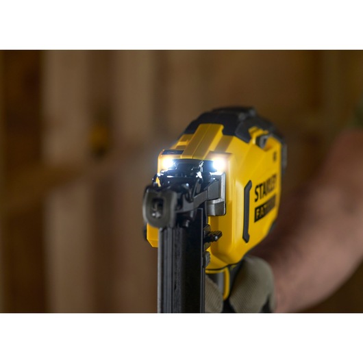STANLEY SFMCN616B nailer close-up with LED lights on, yellow and black tool in use.