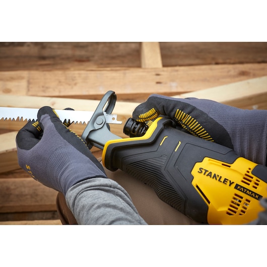 Stanley SFMCS300B reciprocating saw, close-up of blade installation, yellow and black, gloved hands.