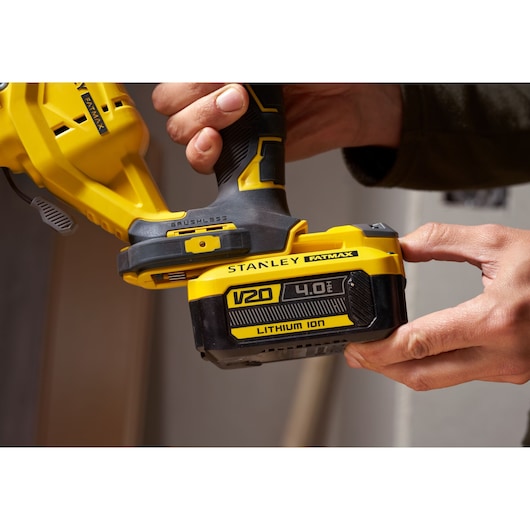 Photo of STANLEY SFMCS650B 18V FATMAX V20 brushless jigsaw held in hand, showing V20 Lithium Ion battery close-up.