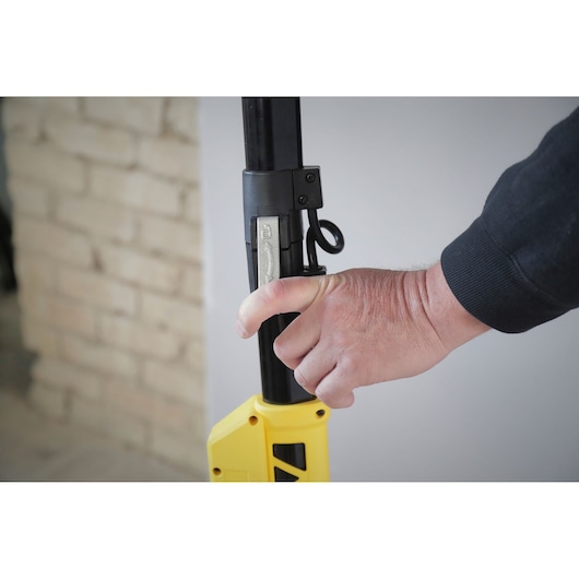 STANLEY SFMEE500S photography of a hand adjusting the locking lever on a yellow and black tool pole.