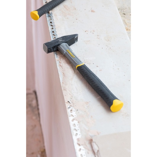 STANLEY STHT0-51908 club hammer with black and yellow handle on a concrete surface, product photography.