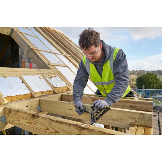 STANLEY STHT46101-0 square used to mark wooden beams on a rooftop construction site.