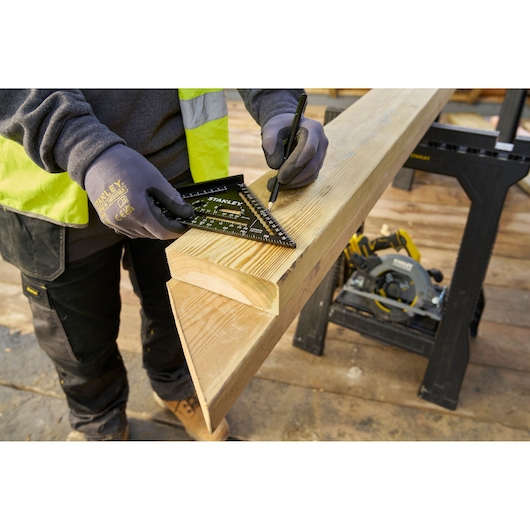 STANLEY STHT46101-0 carpenter's square marking wood on job site, close-up photography.