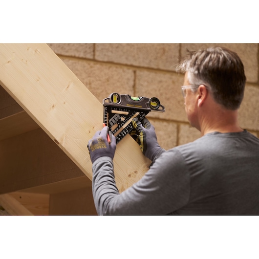 STANLEY STHT46101-0 combination square used by a person marking lines on a wooden beam.
