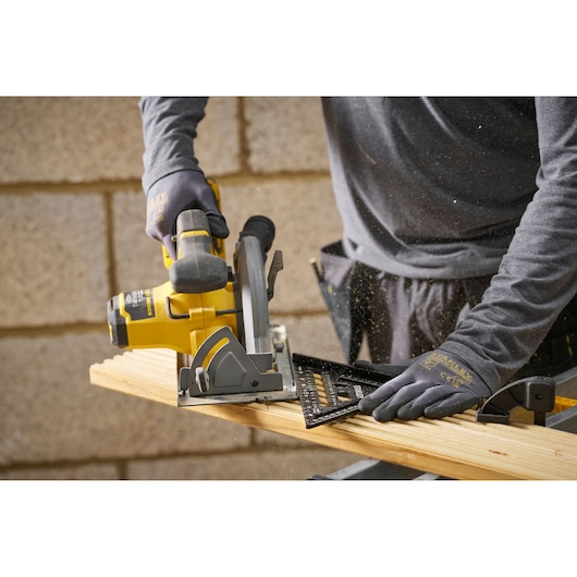 STANLEY STHT46101-0 black speed square on wood plank during circular saw cutting, used by person in gloves.