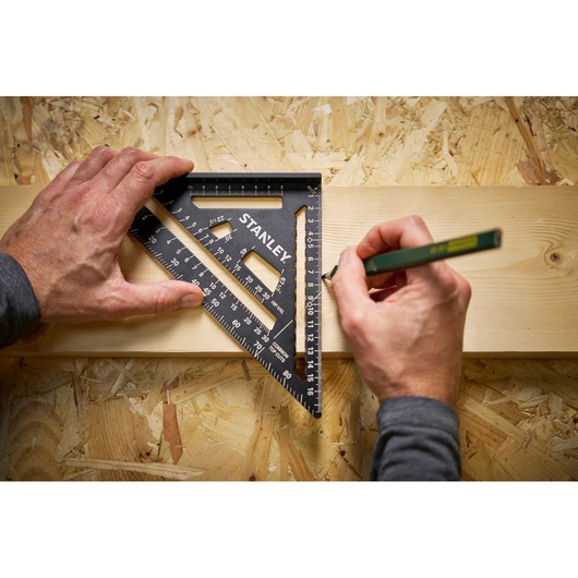 STANLEY STHT46101-0 photography showing black speed square being used to mark a wooden board.