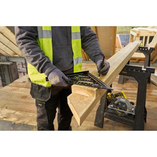 STANLEY STHT46102-0 rafter square in use marking wood, outdoor construction site, product demonstration.