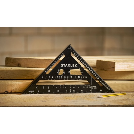 STANLEY STHT46102-0 photography of black triangular carpenter's square on wooden planks with pencil.