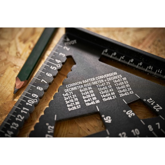 STANLEY STHT46102-0 photography of black carpenter's square with conversion table and green pencil on wood surface.