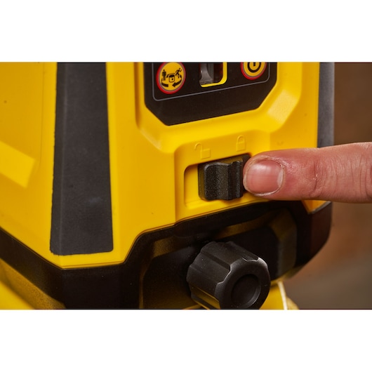 STANLEY STHT77616-0 photography of yellow and black laser level switch being pressed close-up.