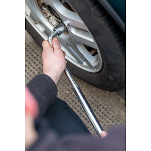 Photo of STANLEY STHT80890-0 wrench being used to loosen a car wheel lug nut.