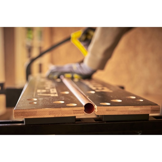 STANLEY STST83400-1 workbench photography, angled view with copper pipe and gloved hand.