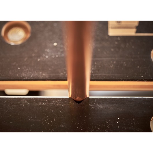 STANLEY STST83400-1 photography of a copper pipe fitted into a black metal workbench groove.